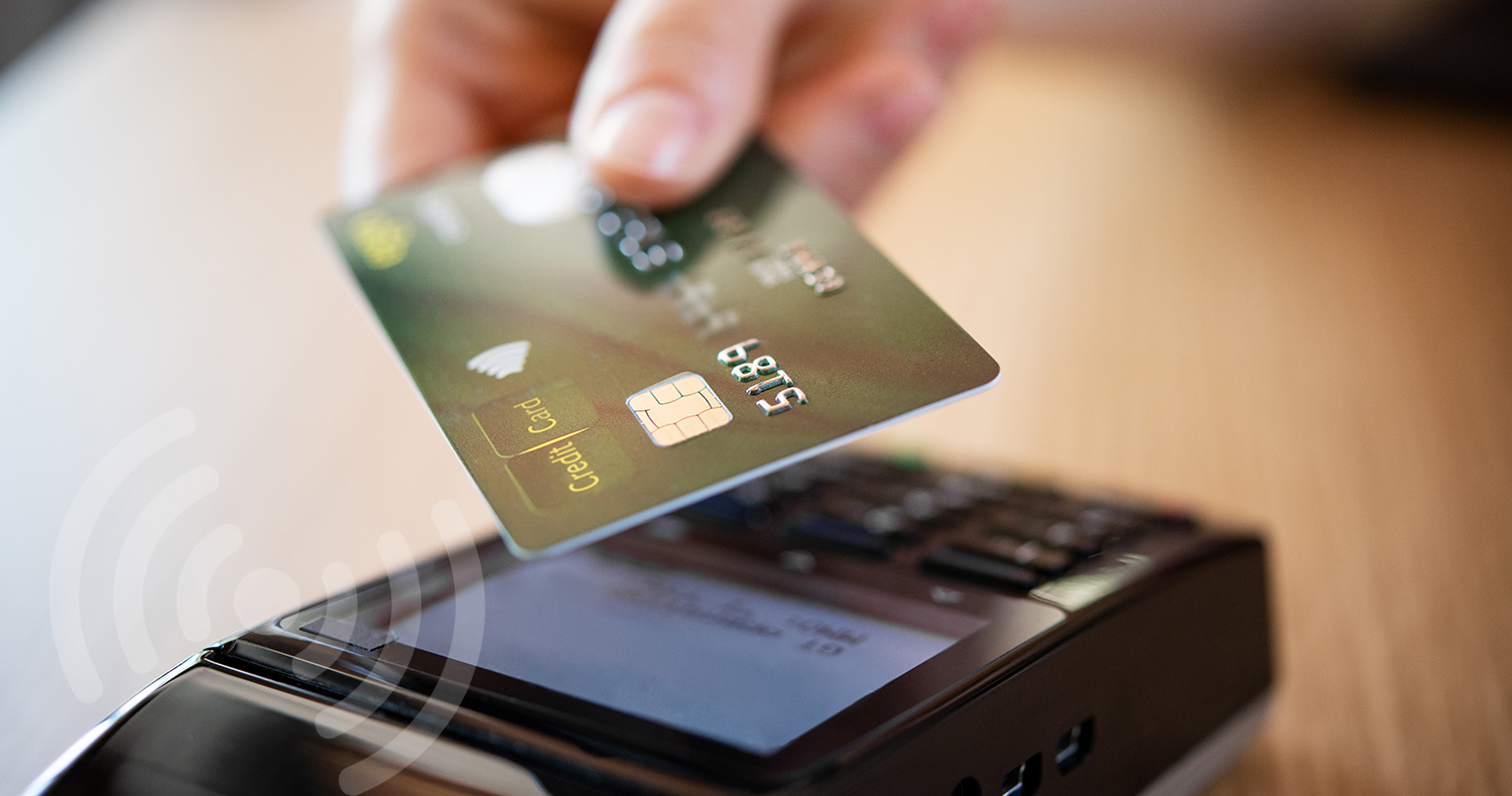 Close up hand of woman paying bill with credit card by contactless. Hand of customer make payment with contactless credit card with NFC technology on terminal device. Closeup of mobile payment at coffee shop or restaurant with card reader machine.