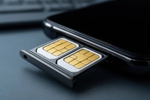 close-up shows dual SIM card tray being inserted into smartphone