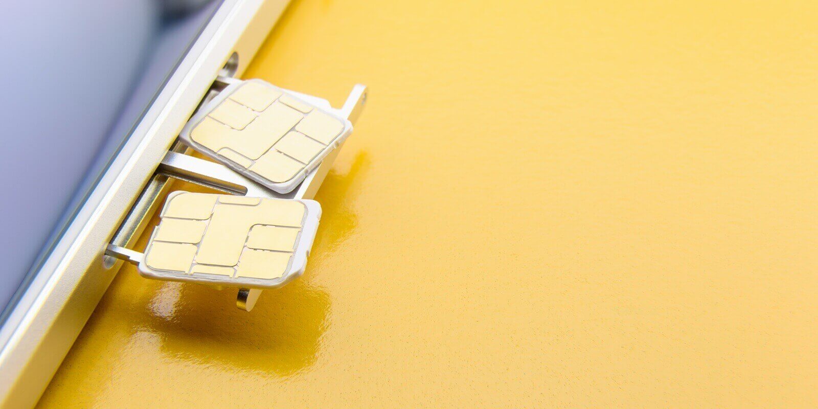 dual SIM card slot with two nano SIM cards on yellow background