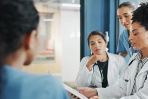 nurse and women on clipboard in meeting