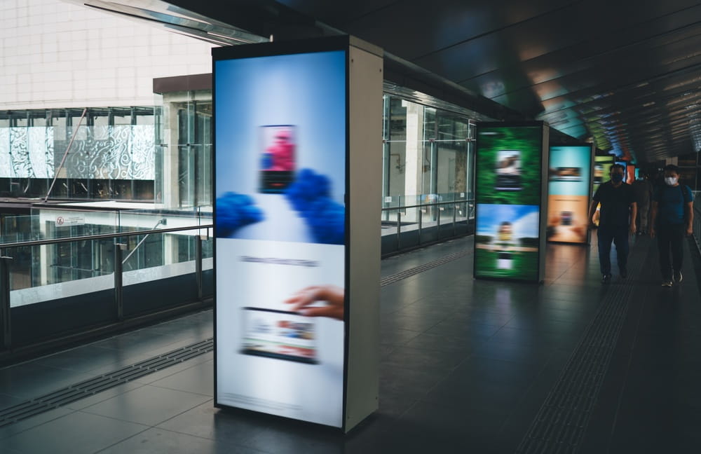 digital signage in transportation point with blurred people hurrying past